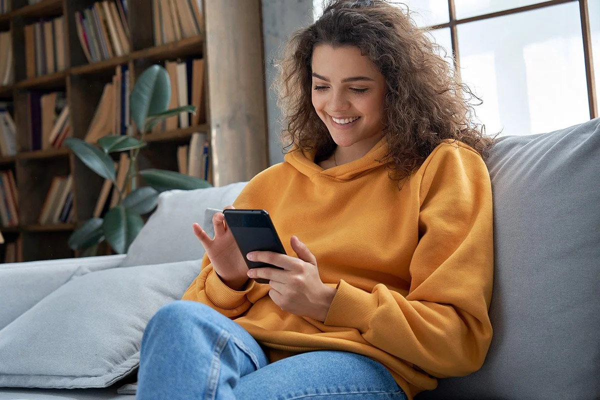 Mujer sonriente mirando su teléfono